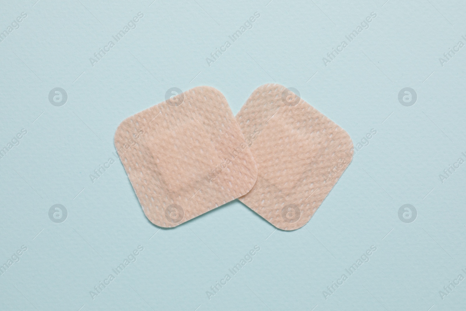 Photo of Contraceptive patches on light blue background, flat lay