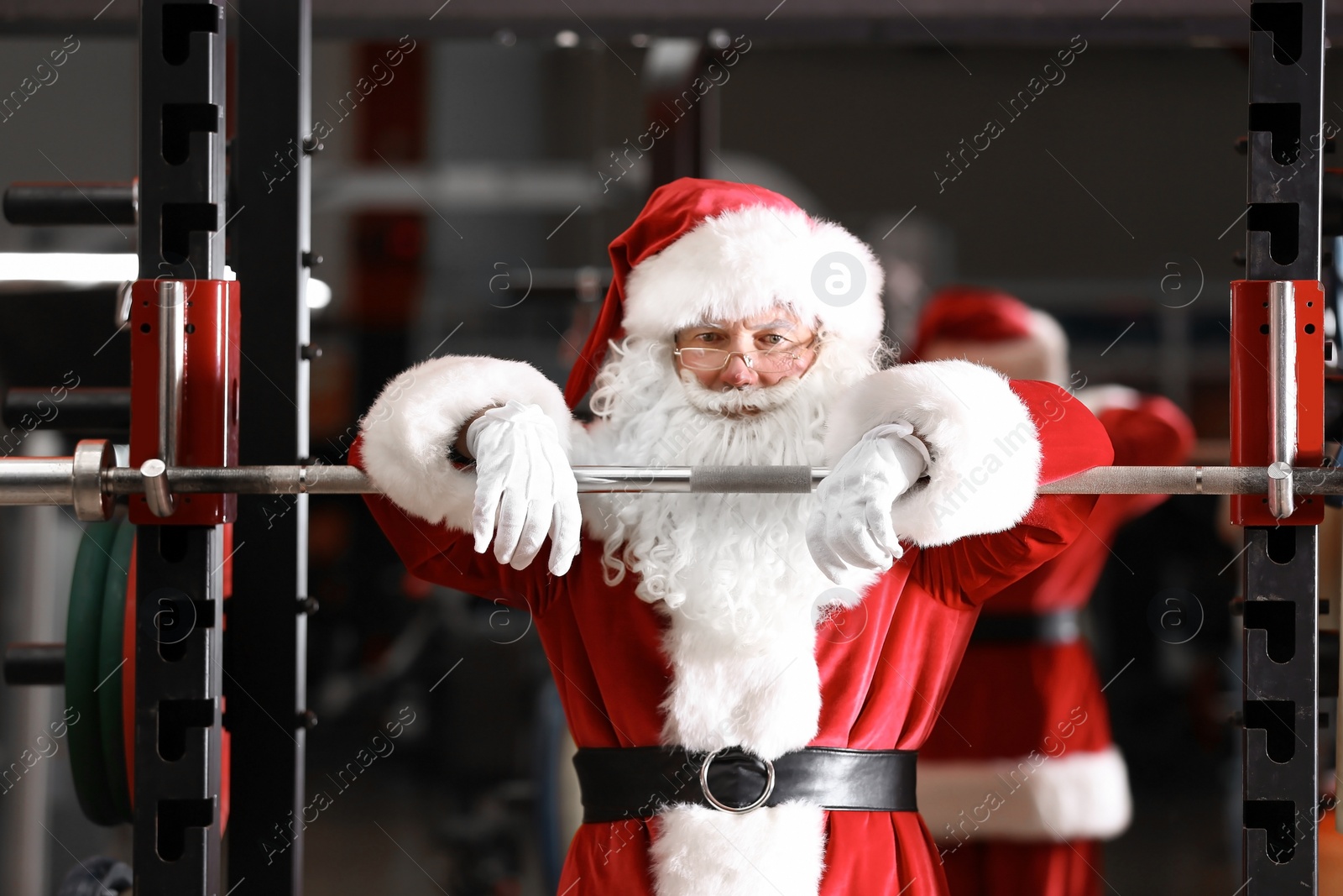 Photo of Authentic Santa Claus resting after exercise in modern gym