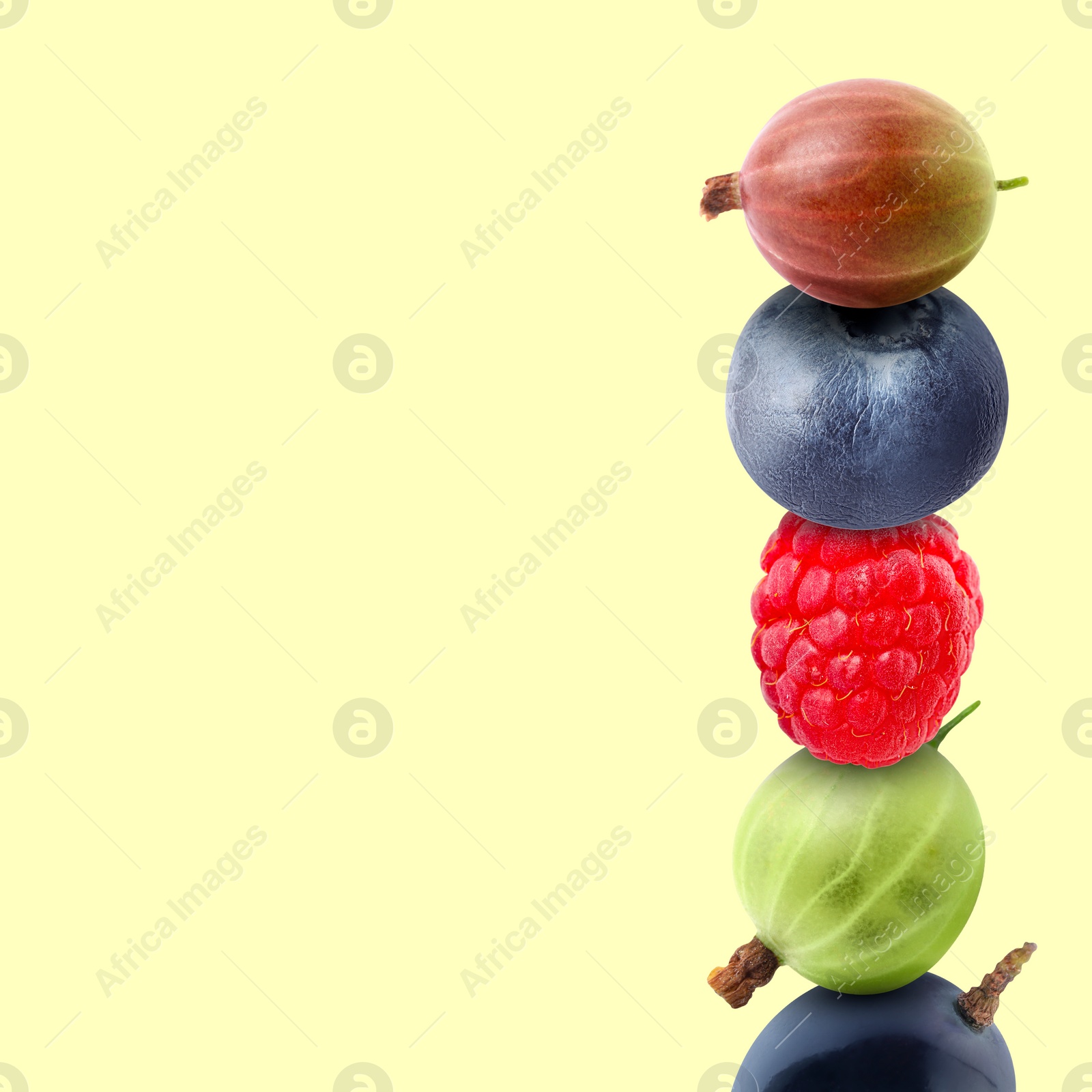 Image of Stack of different fresh tasty berries on honeydew color background, space for text