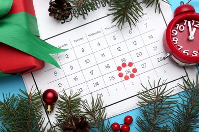 Photo of Flat lay composition with calendar and gift on light blue background. Boxing day concept