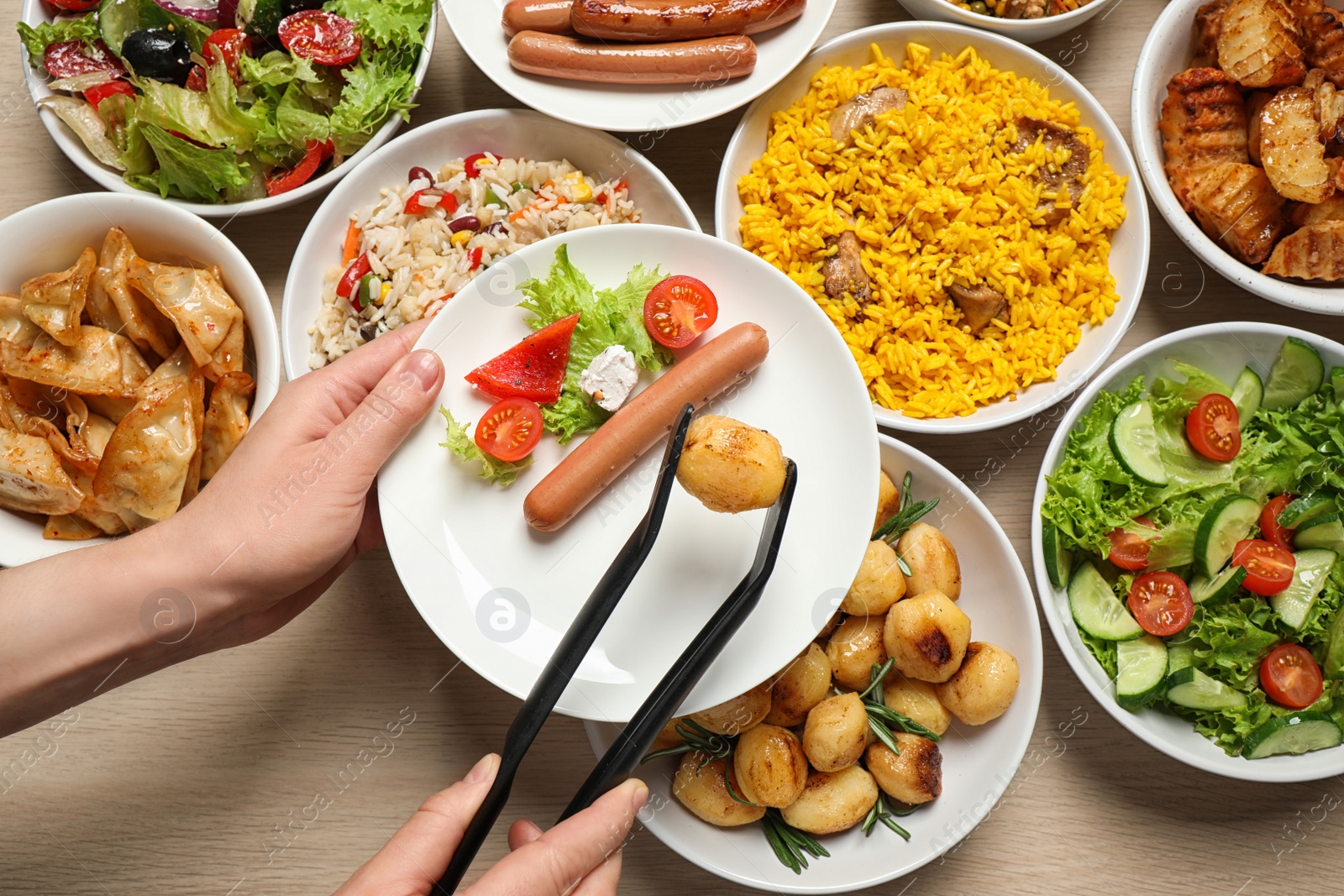 Photo of Woman taking food from buffet table, closeup