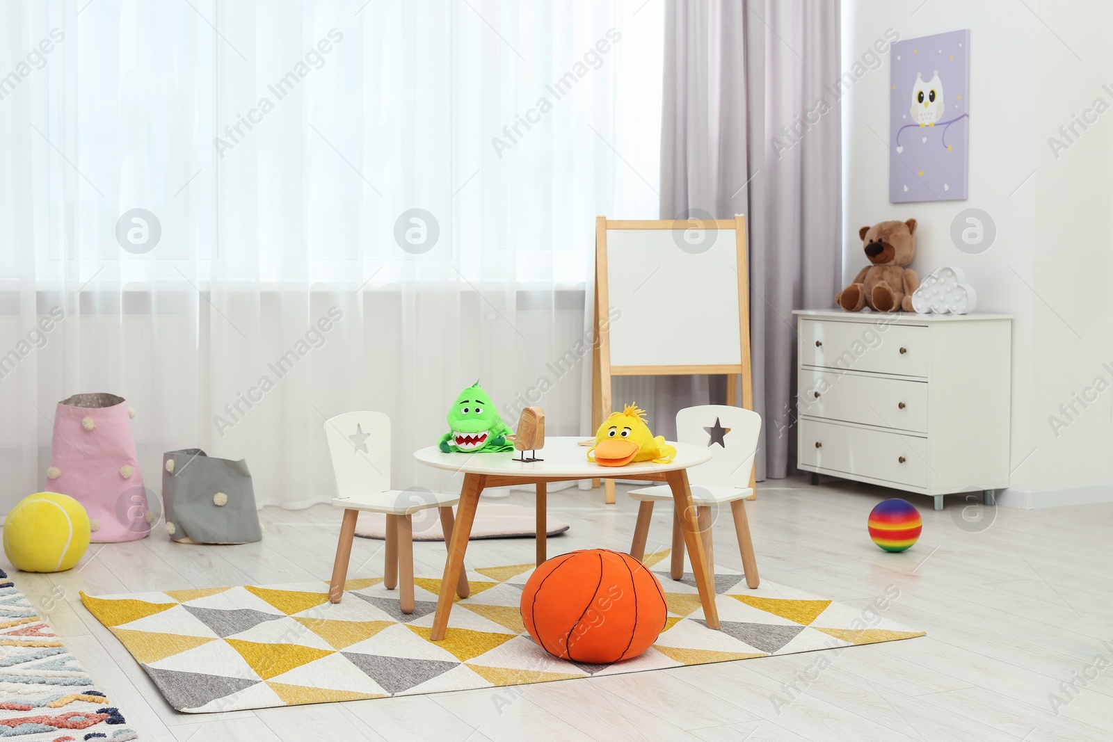 Photo of Child`s playroom with different toys and modern furniture. Stylish kindergarten interior