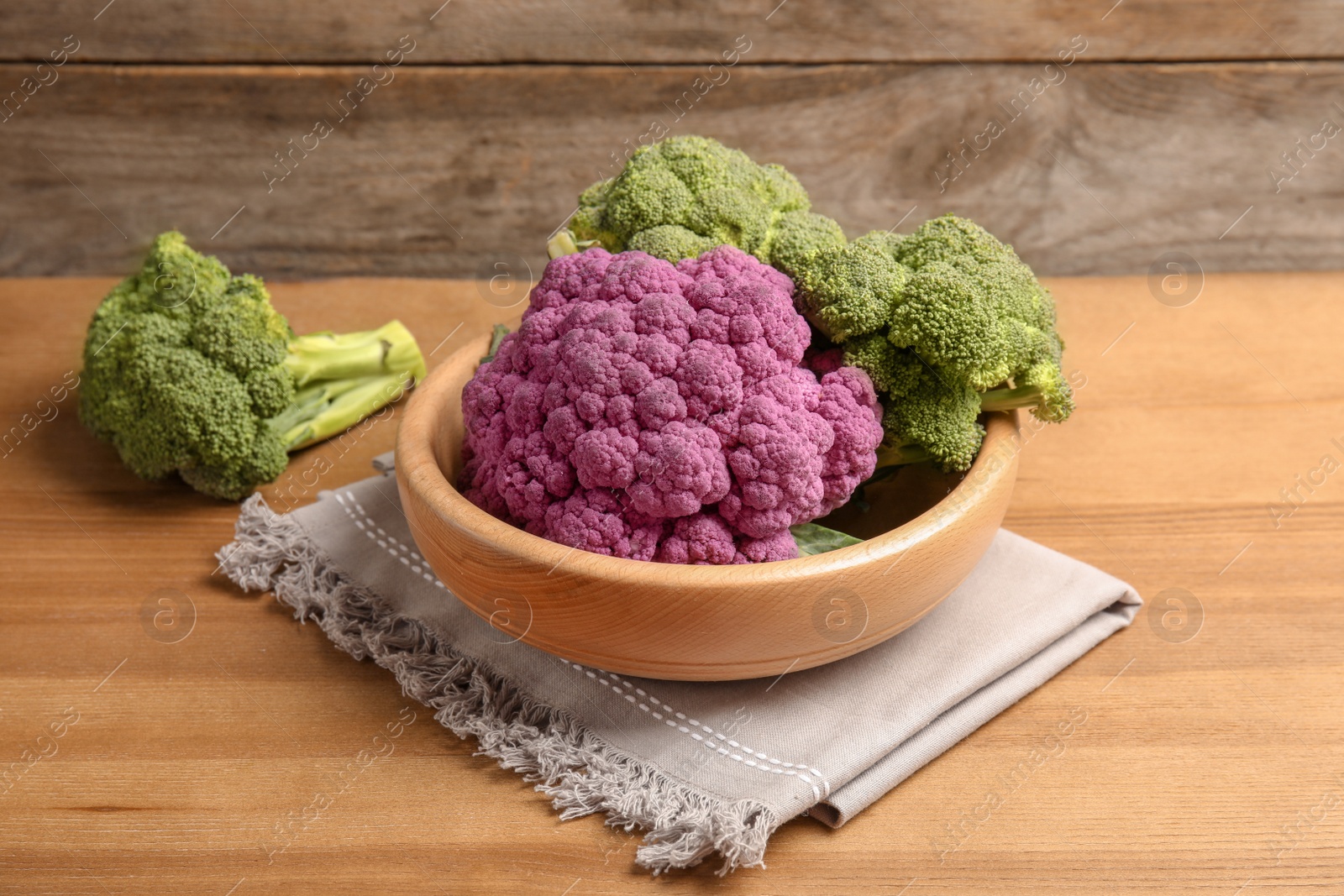 Photo of Plate with different cabbages on wooden table. Healthy food