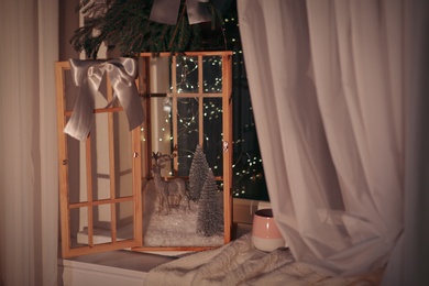 Vintage wooden lantern with beautiful Christmas composition on window sill indoors