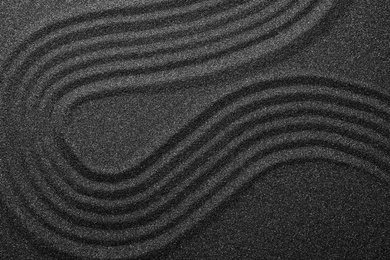 Black sand with beautiful pattern, top view. Zen concept