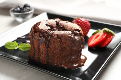 Delicious fresh fondant with hot chocolate and strawberries served on plate. Lava cake recipe