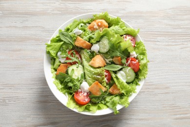 Delicious salad with chicken and vegetables on wooden table, top view