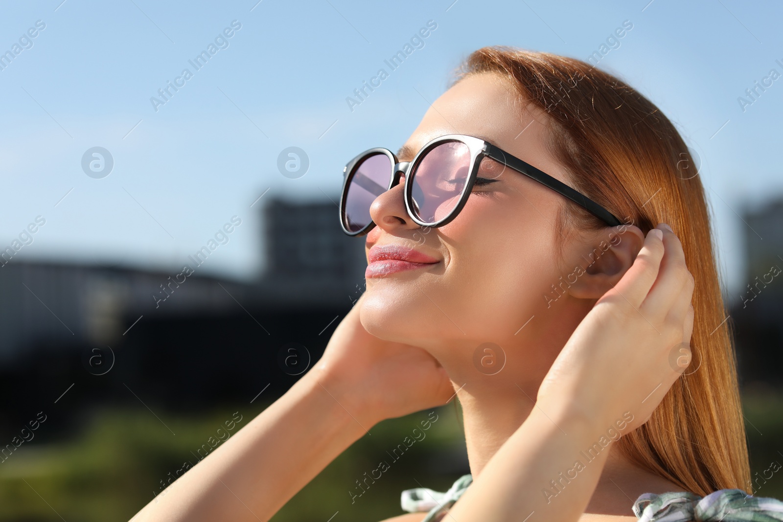 Photo of Beautiful woman in sunglasses outdoors. Space for text