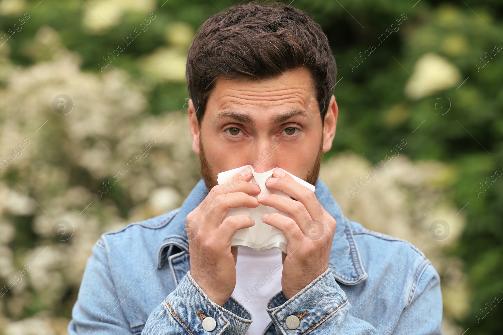 Photo of Man suffering from seasonal spring allergy outdoors