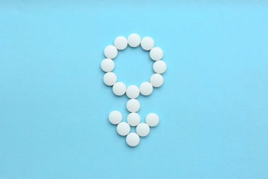 Photo of Male sign made of white pills on light blue background, flat lay. Potency problems