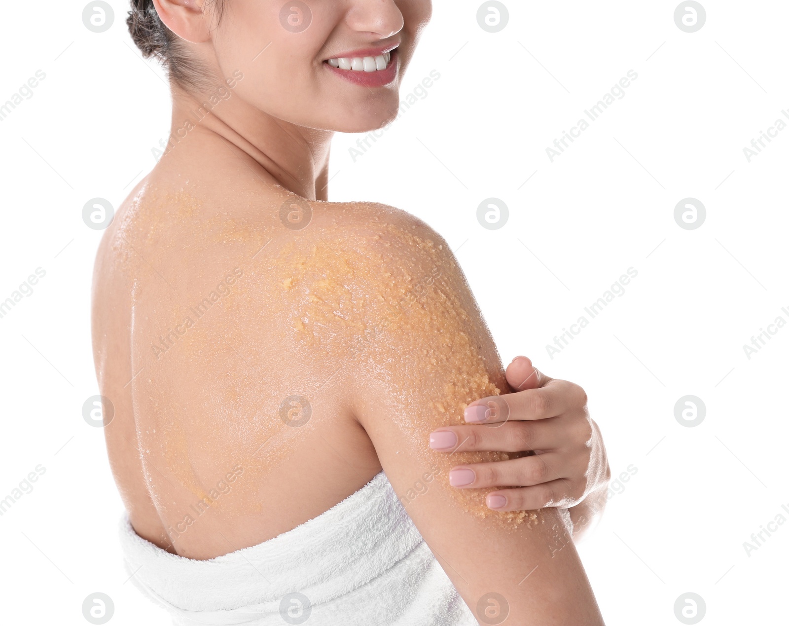 Photo of Young woman applying body scrub on her shoulder against white background
