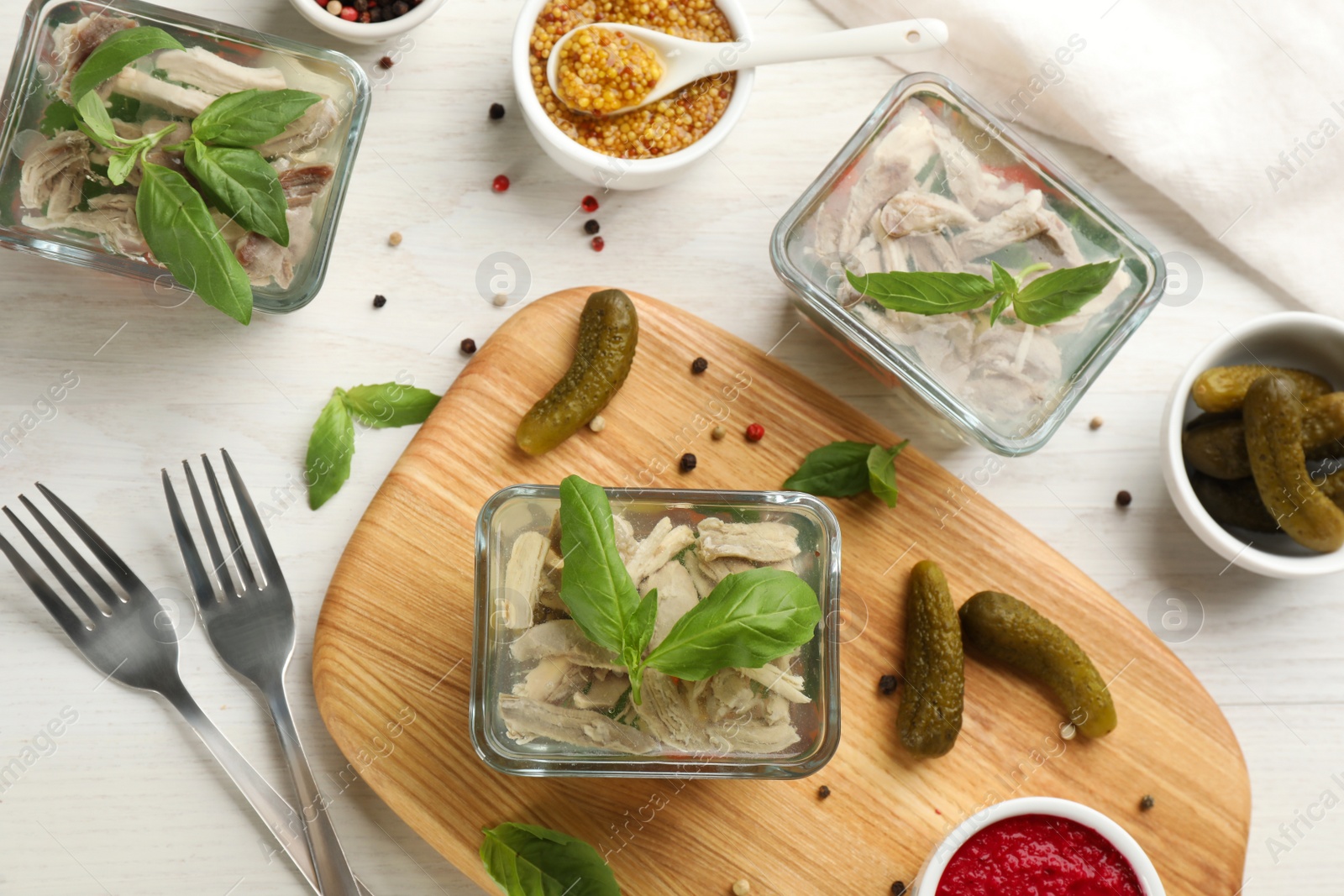 Photo of Delicious aspic and ingredients served on white wooden table, flat lay