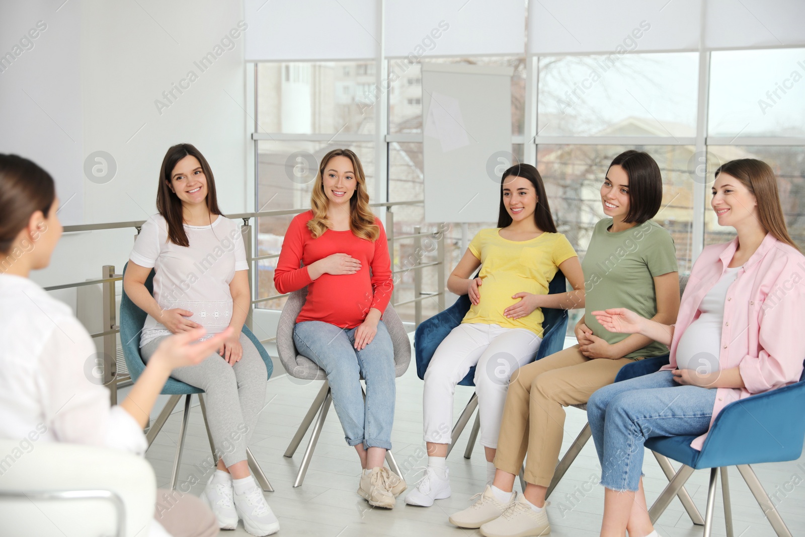 Photo of Group of pregnant women with doctor at courses for expectant mothers indoors