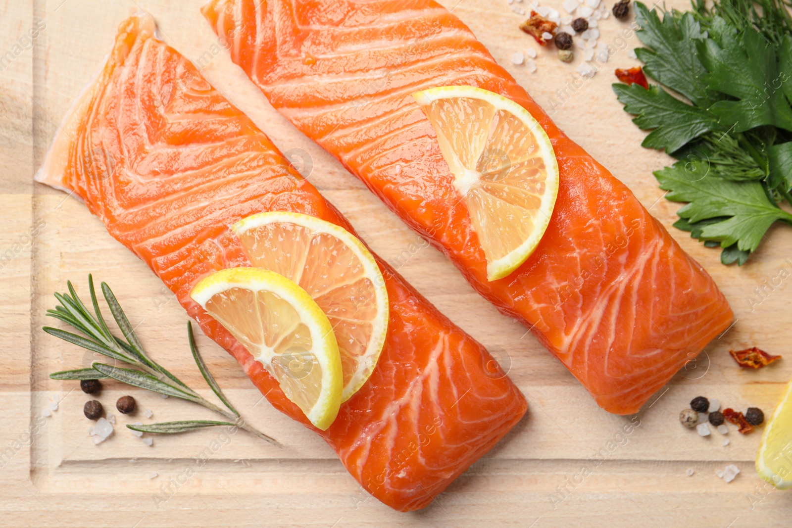 Photo of Fresh salmon and ingredients for marinade on wooden board, flat lay