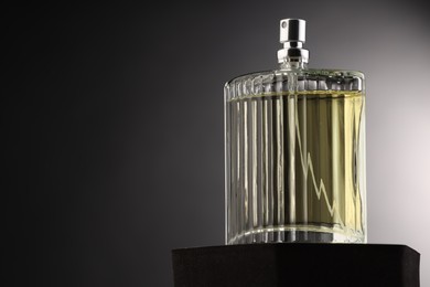 Photo of Luxury men`s perfume in bottle against grey background, space for text