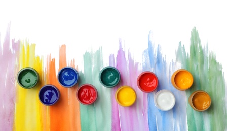 Photo of Composition with different paints in jars on light background, top view. Color palette