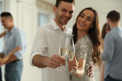 Photo of Lovely young couple with glasses of champagne at dancing party, focus on hands