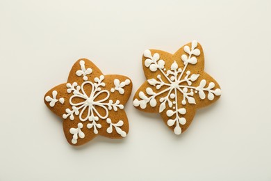 Tasty Christmas cookies with icing on white background, flat lay