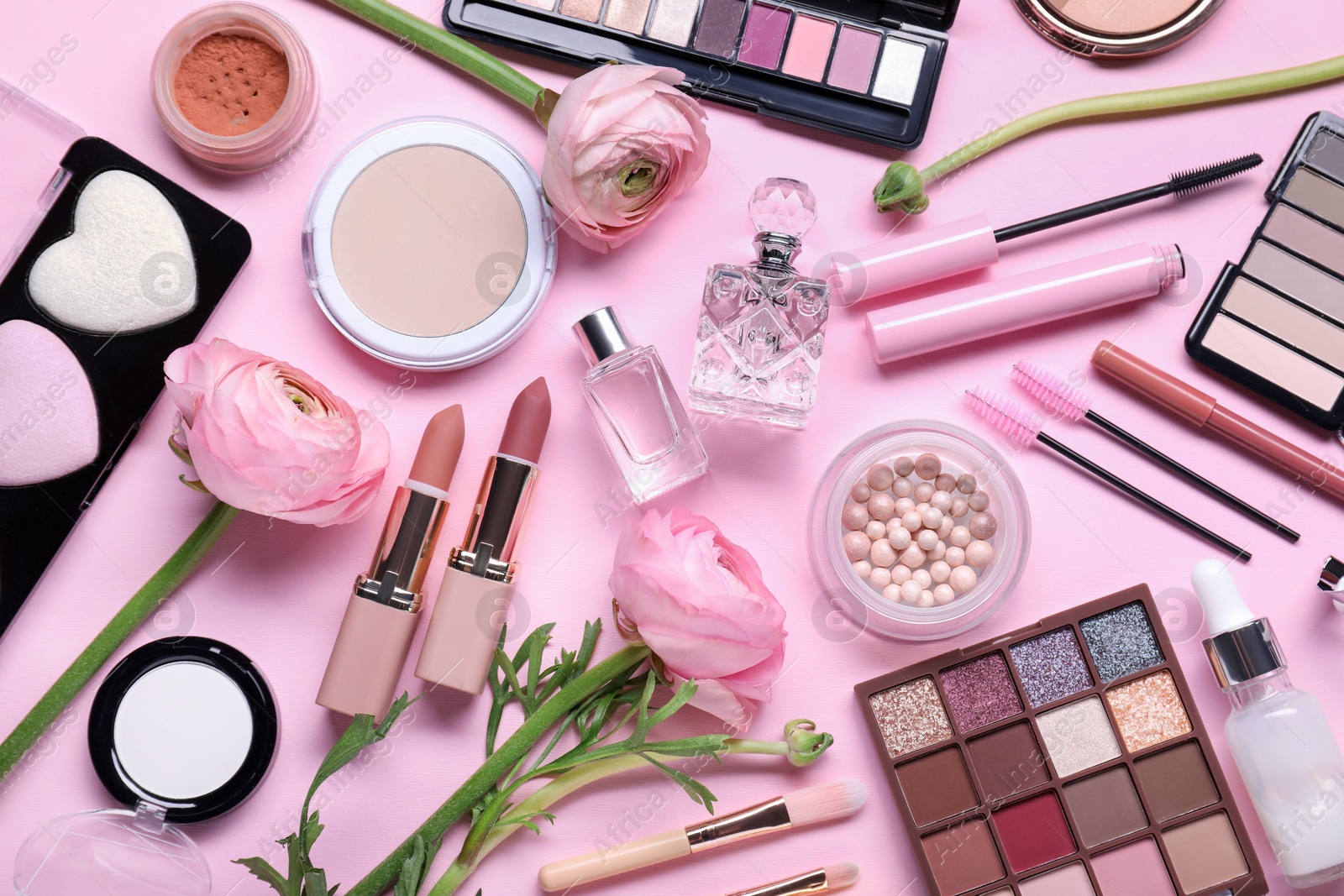 Photo of Flat lay composition with different makeup products and beautiful spring flowers on pink background