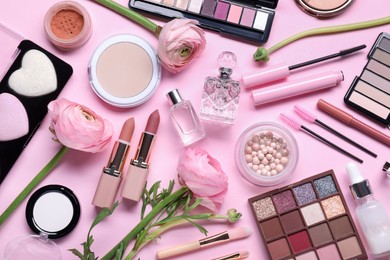 Photo of Flat lay composition with different makeup products and beautiful spring flowers on pink background