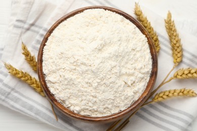 Bowl of organic wheat flour on white wooden table, top view