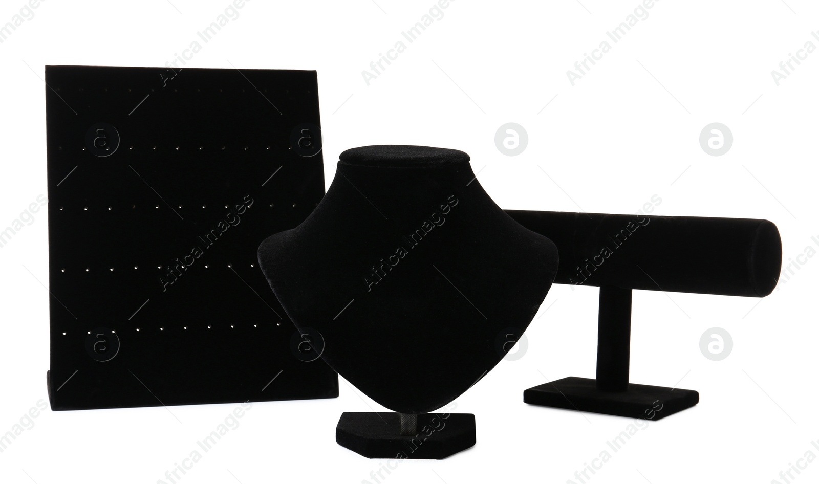 Photo of Different empty black velvet jewelry stands on white background