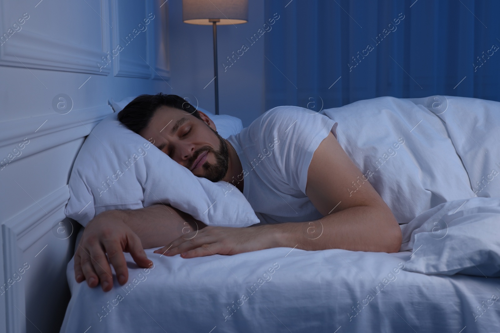 Photo of Handsome man sleeping in bed at night