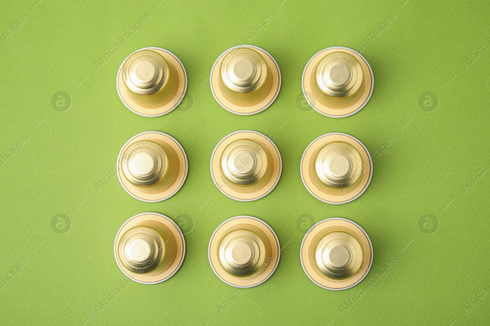 Photo of Many coffee capsules on green background, flat lay
