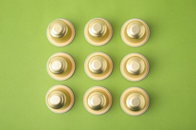 Photo of Many coffee capsules on green background, flat lay