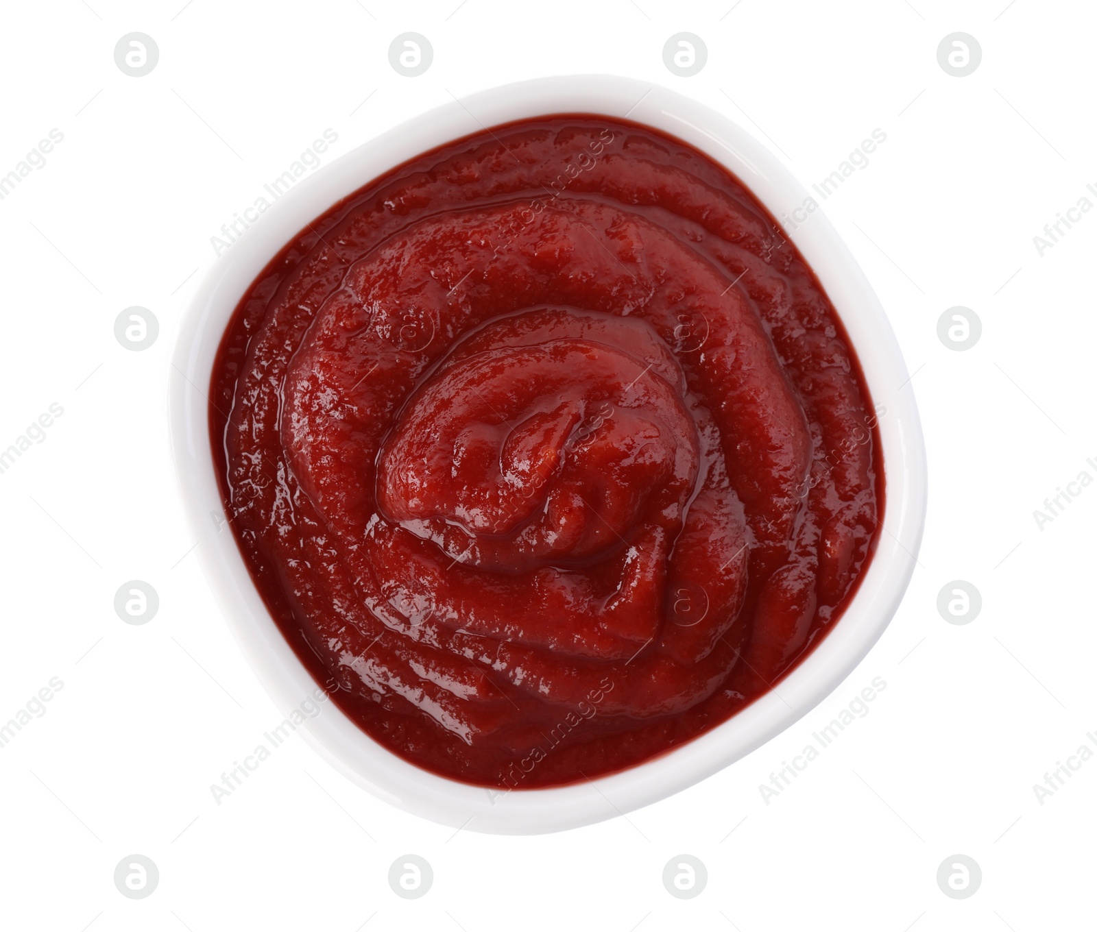 Photo of Tasty ketchup in bowl isolated on white, top view