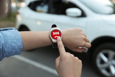 Image of Woman using SOS function on smartwatch outdoors, closeup