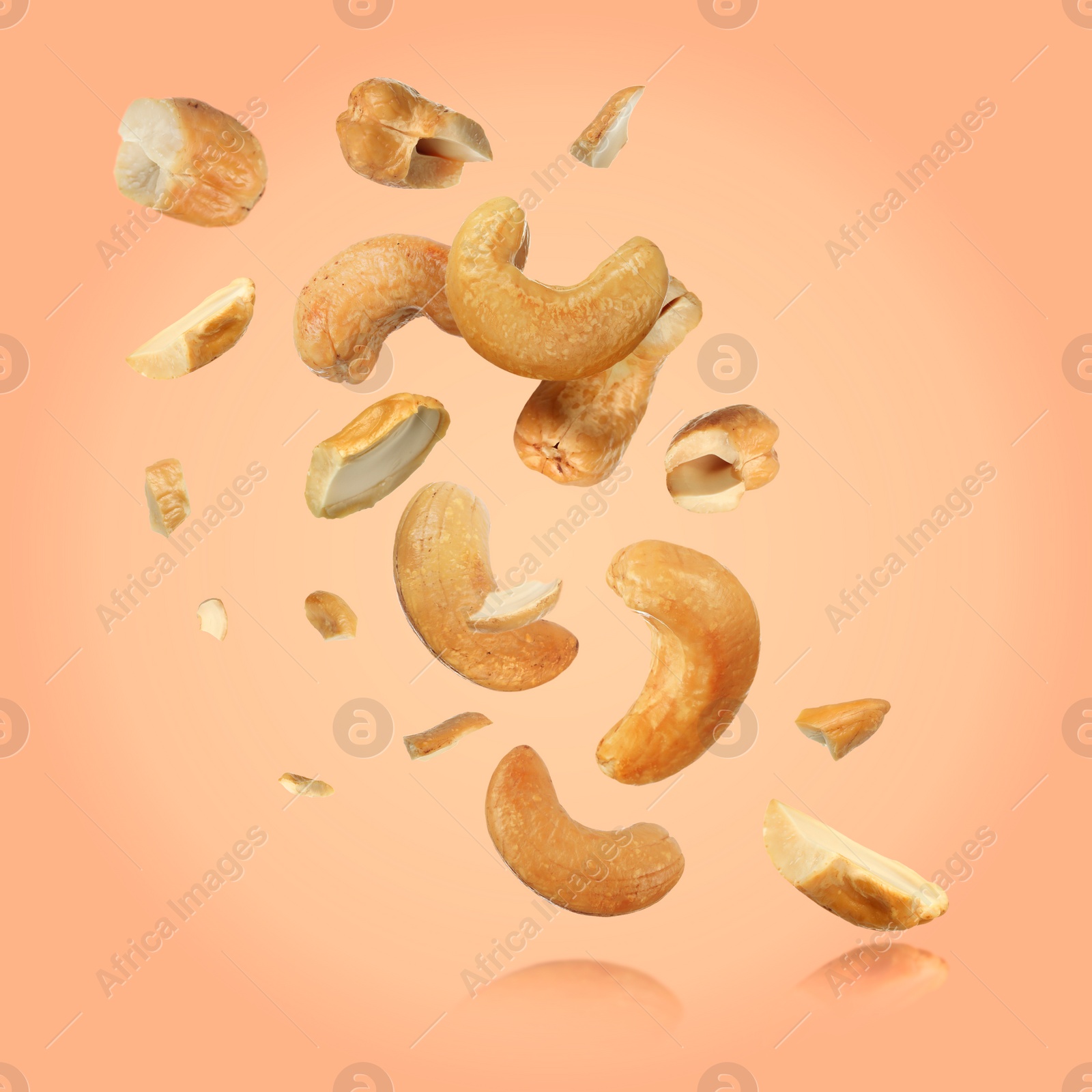 Image of Tasty cashew nuts flying on pink background