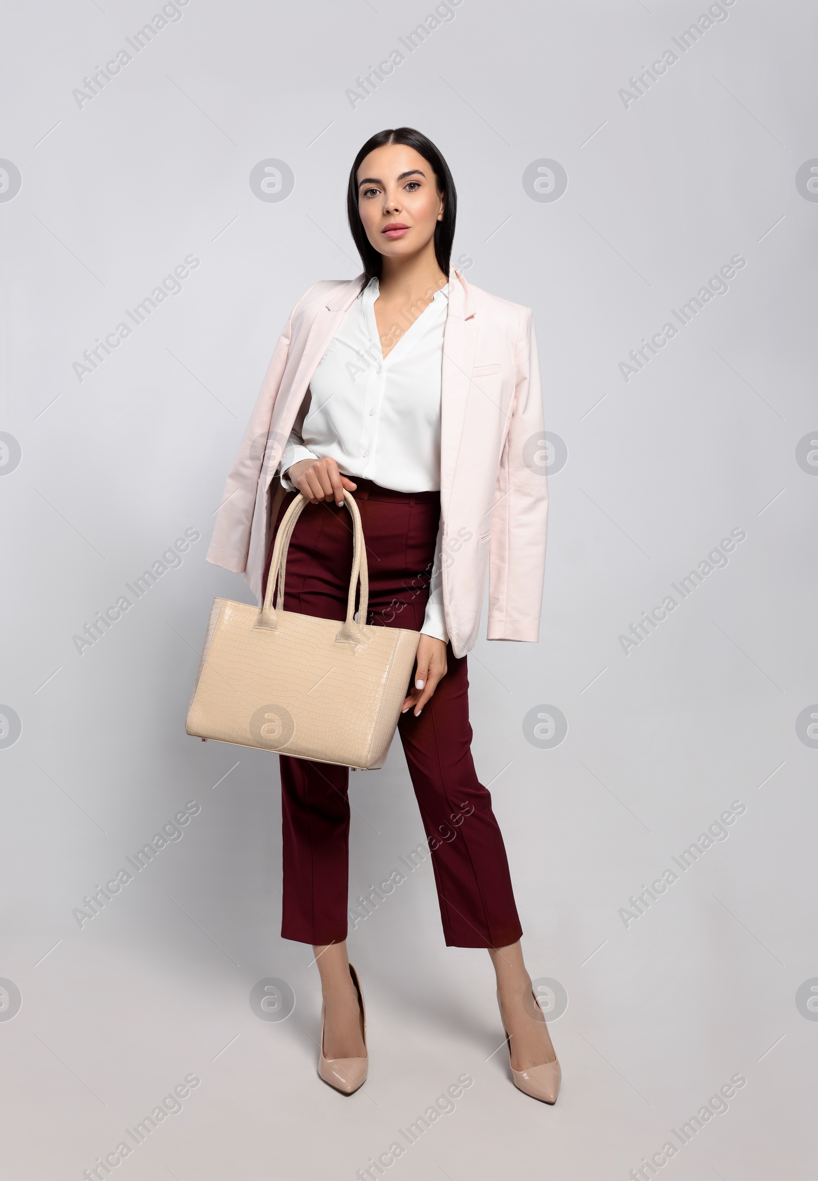 Photo of Young woman with stylish bag on white background