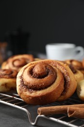 Tasty cinnamon rolls on black table, closeup. Space for text