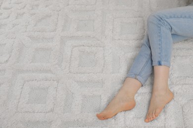 Woman on beige carpet, above view. Space for text