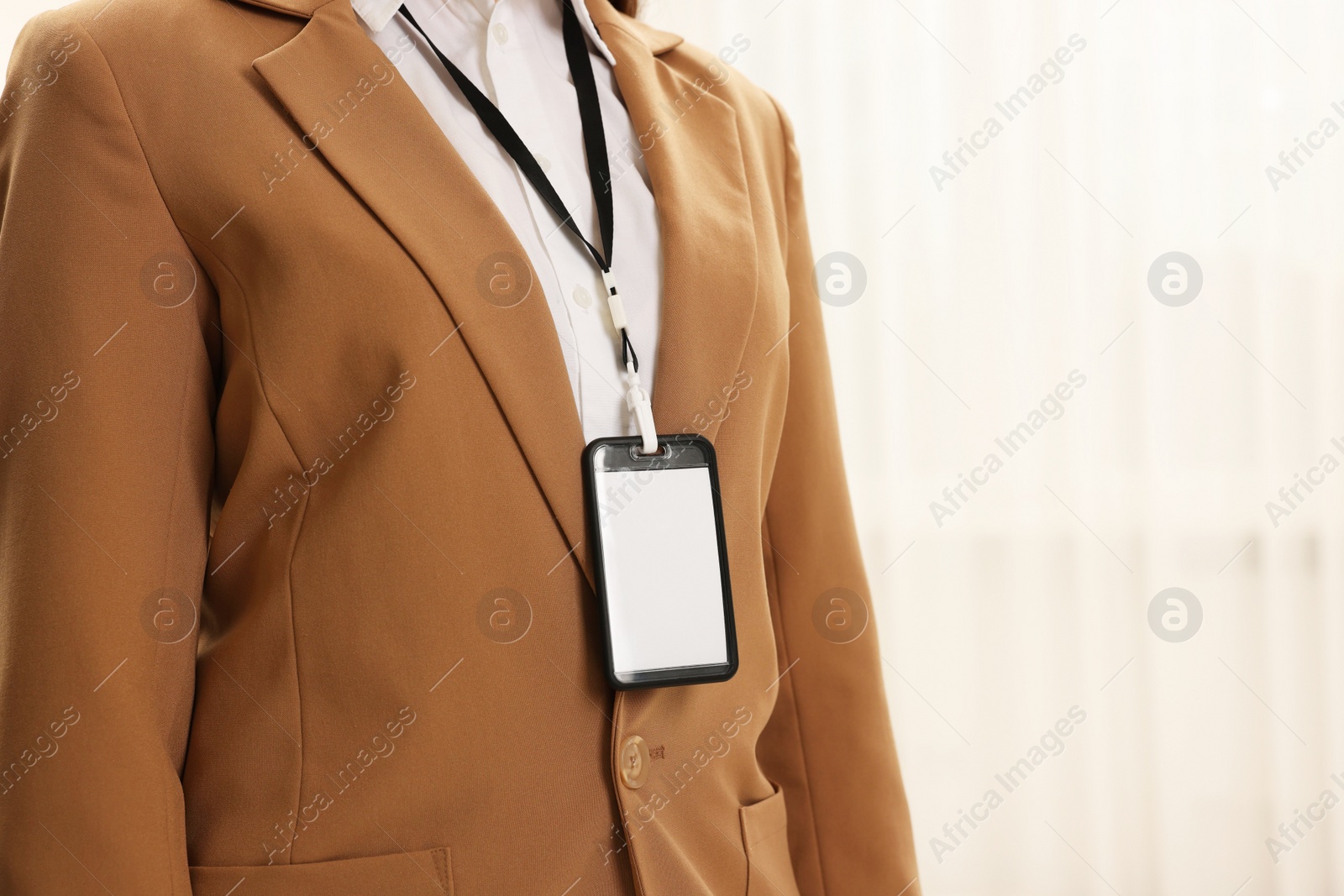 Photo of Woman with blank badge indoors, closeup. Space for text
