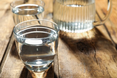 Photo of Glass of water on wooden table, closeup. Refreshing drink