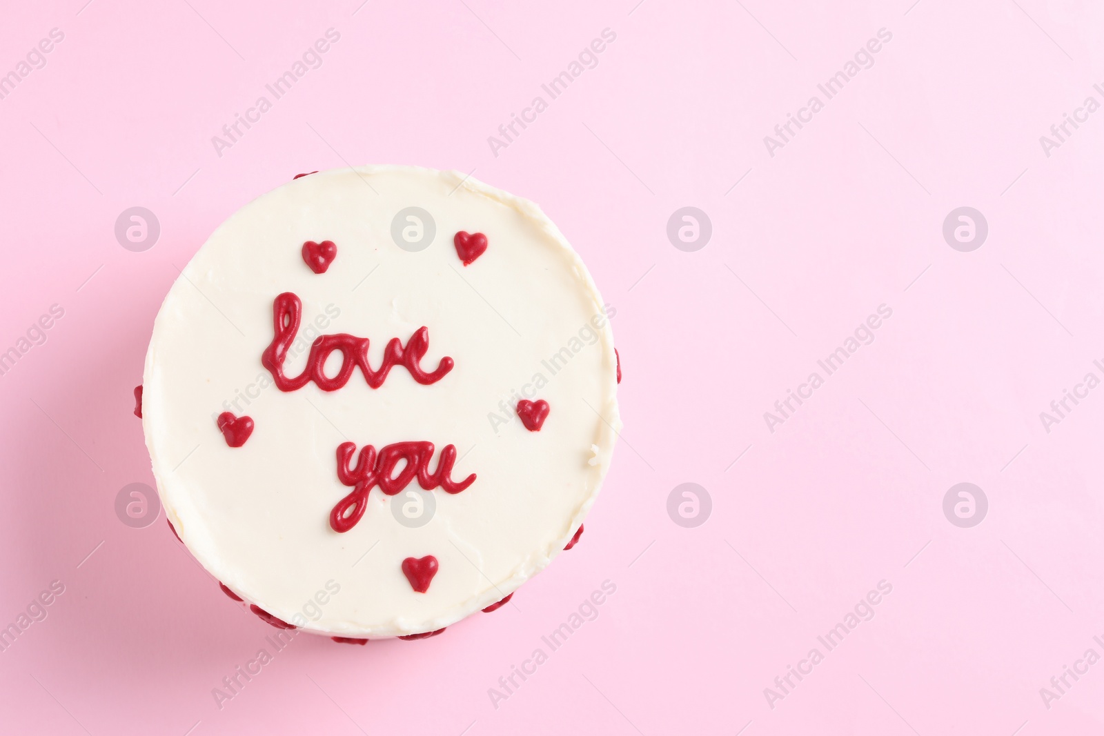 Photo of Bento cake with text Love You and space for text on pink table, top view. St. Valentine's day surprise