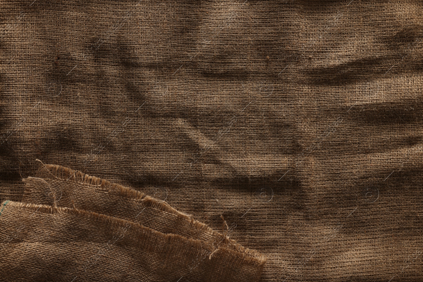 Photo of Texture of natural burlap fabric as background, top view