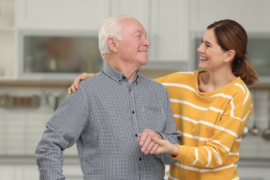 Elderly man with female caregiver in kitchen