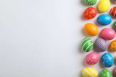 Decorated Easter eggs and space for text on white background, top view