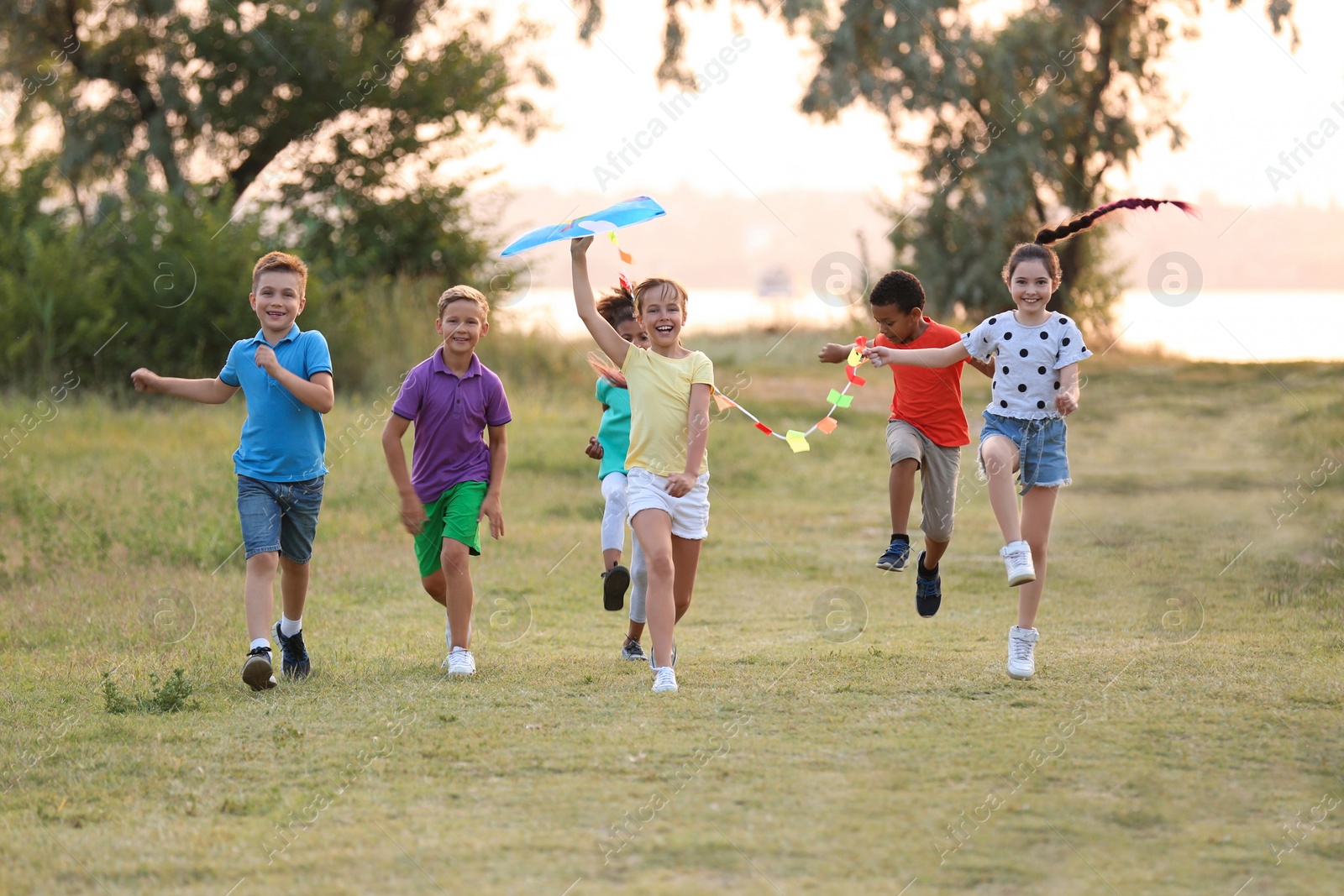 Photo of Cute little children playing with kite outdoors