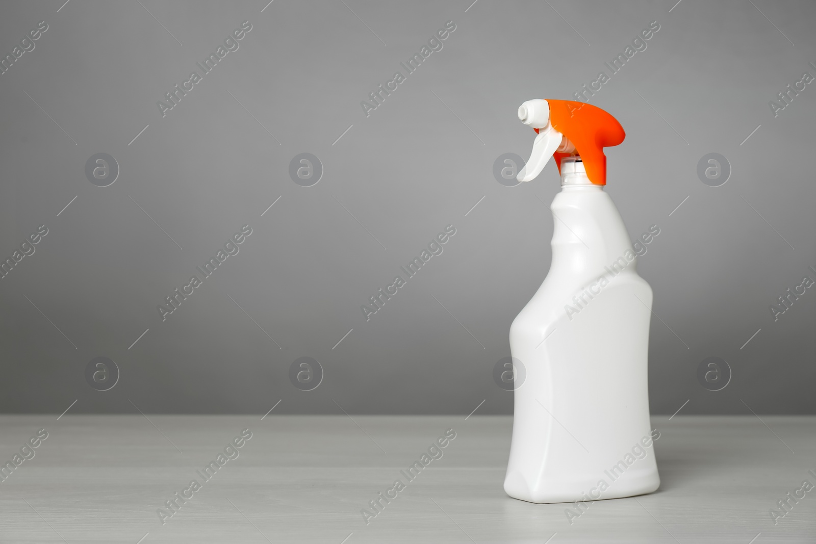 Photo of Bottle of cleaning product on light table. Space for text