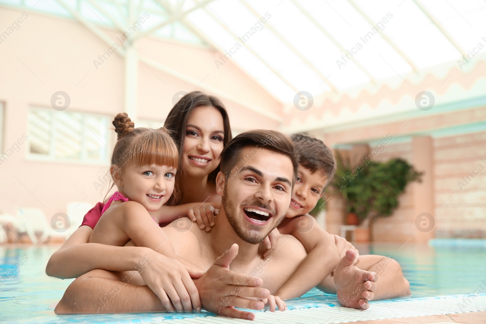 Photo of Happy family resting in indoor swimming pool