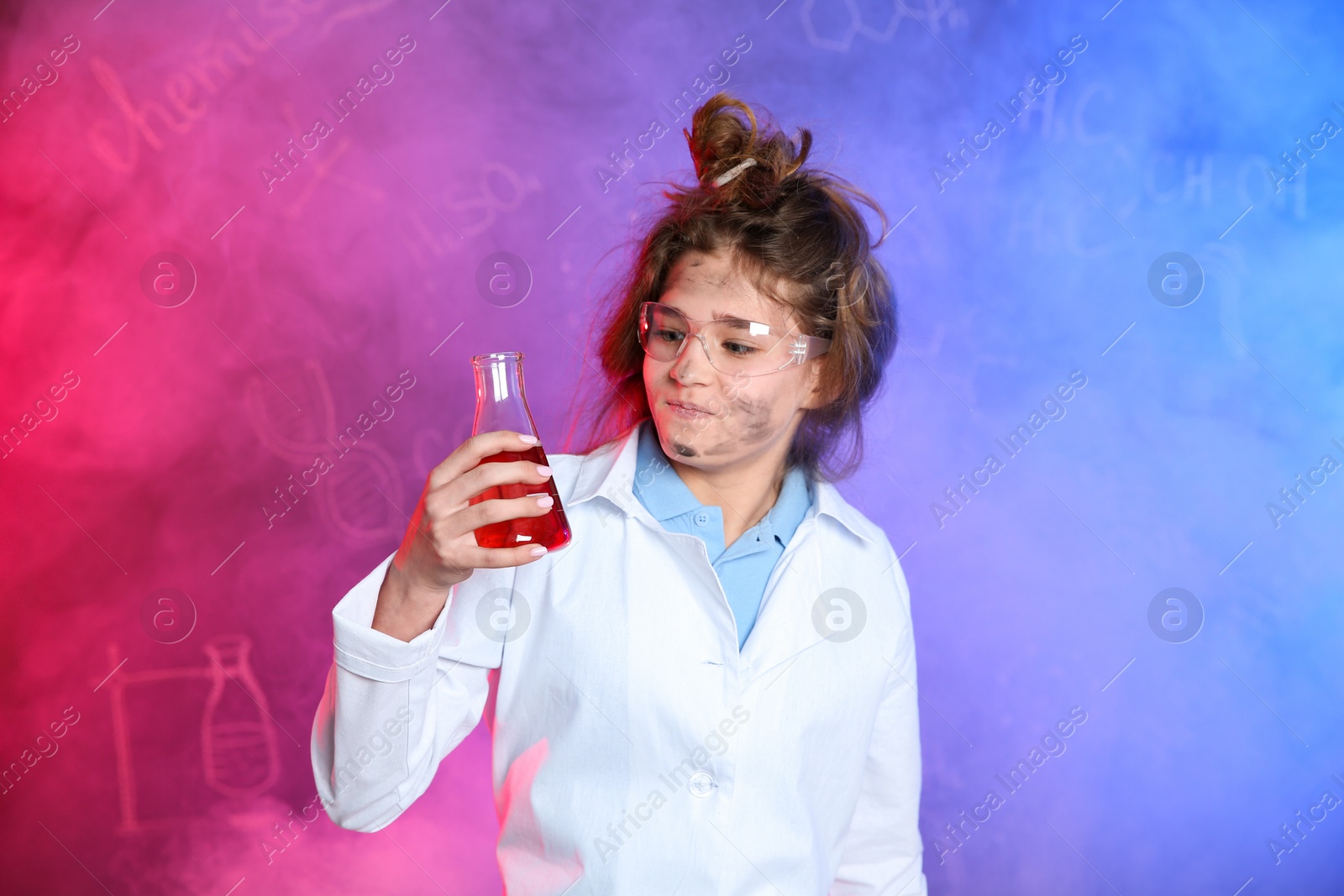 Photo of Emotional pupil holding conical flask in smoke against blackboard with chemistry formulas