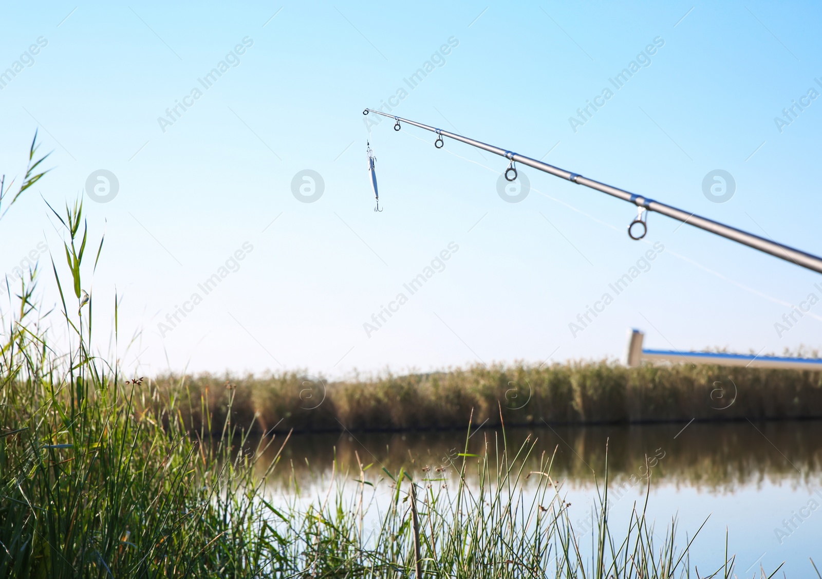 Photo of Fishing rod at riverside on sunny day