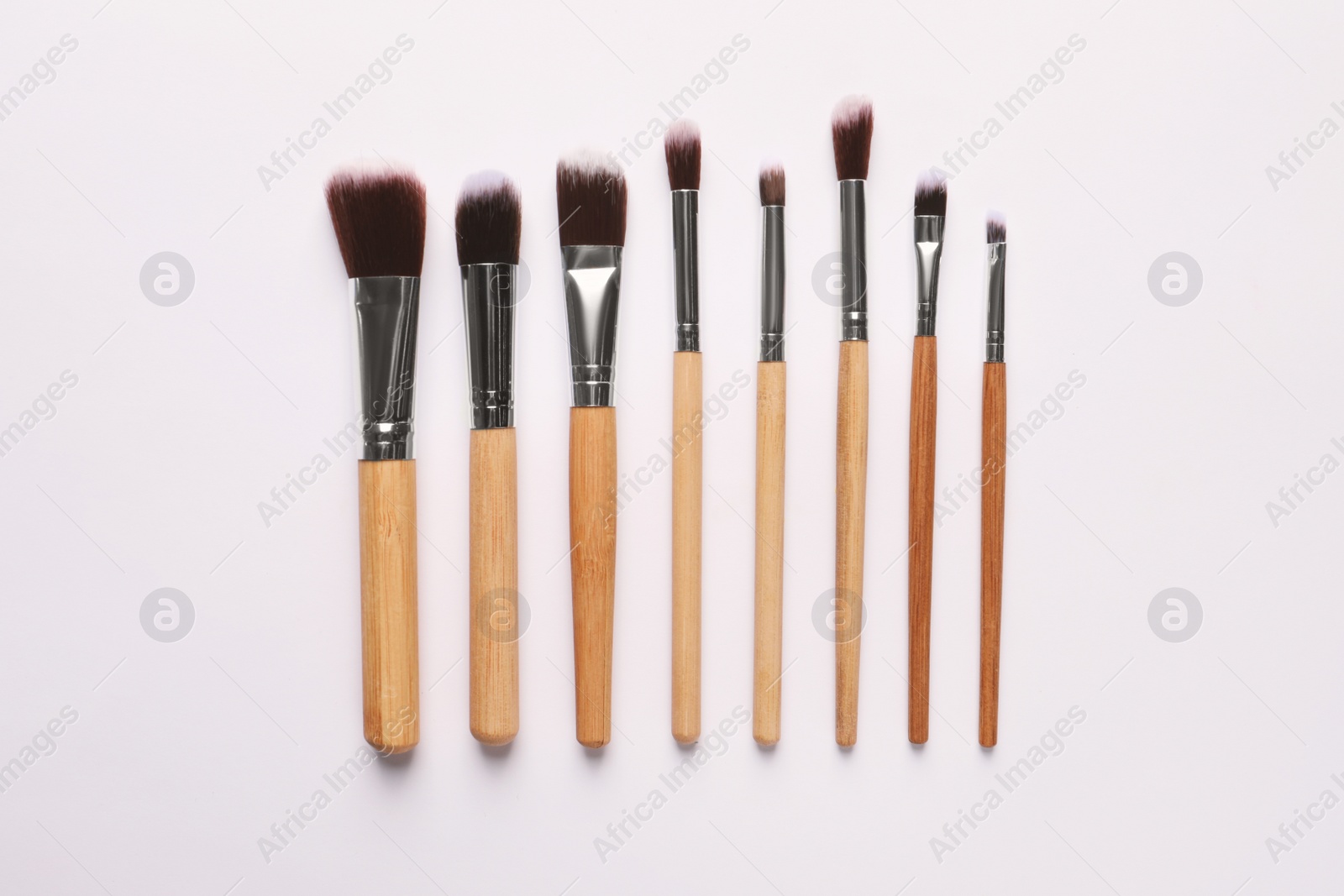 Photo of Different makeup brushes on white background, flat lay