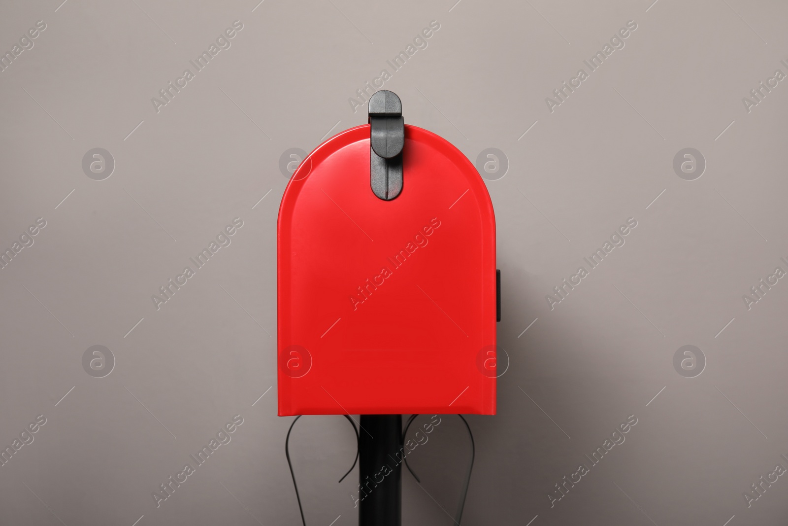 Photo of Closed red letter box against grey background