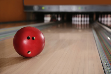 Photo of Red ball on bowling lane in club. Space for text