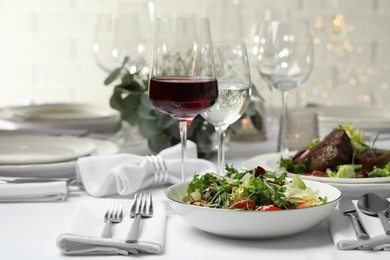 Delicious salad and wine served on table in restaurant
